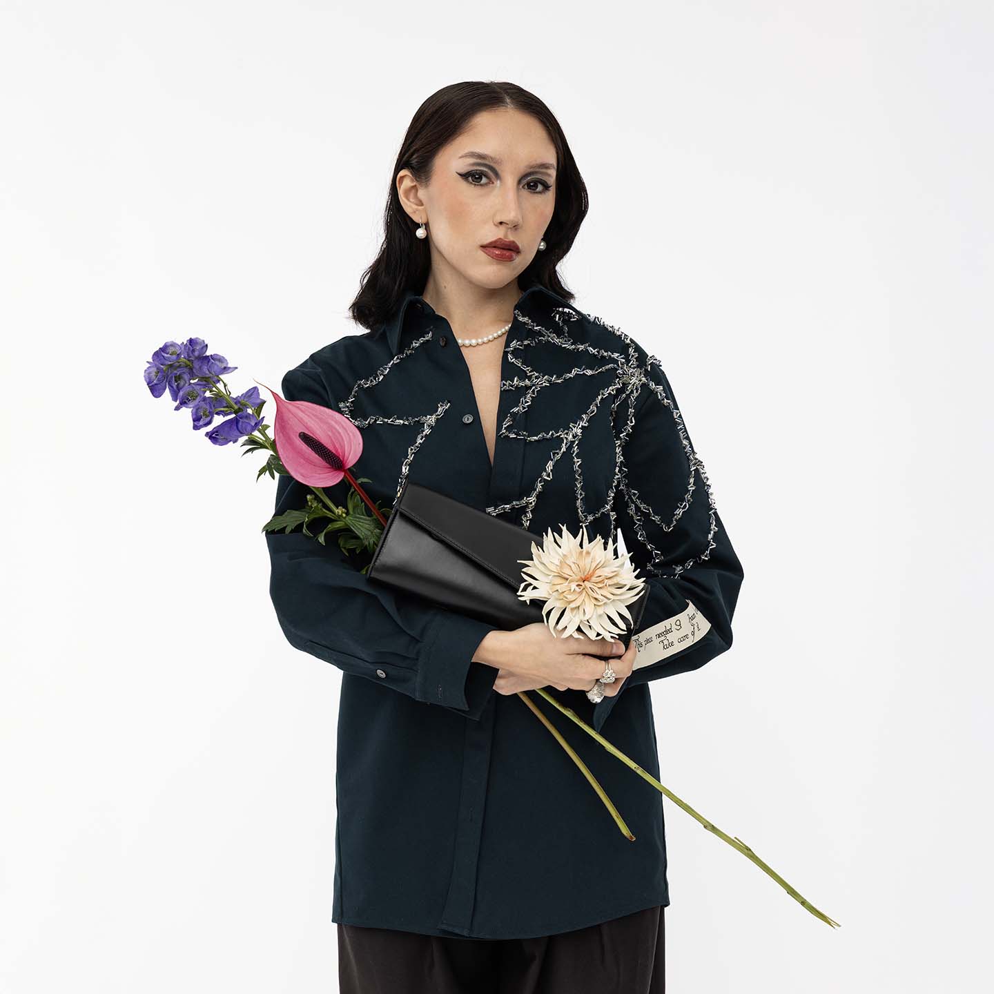 Abendtasche aus Leder schwarz mit weißer Dahlie Frontansicht mit Model