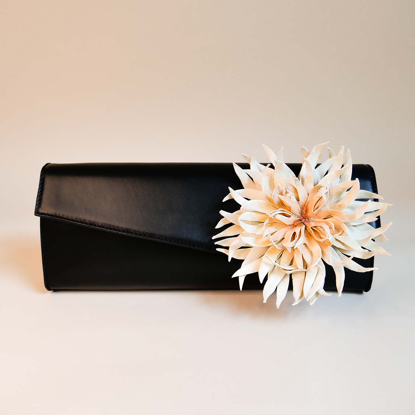 Elegante Clutch aus schwarzem Leder mit der Signature flower Dahlia zum anstecken