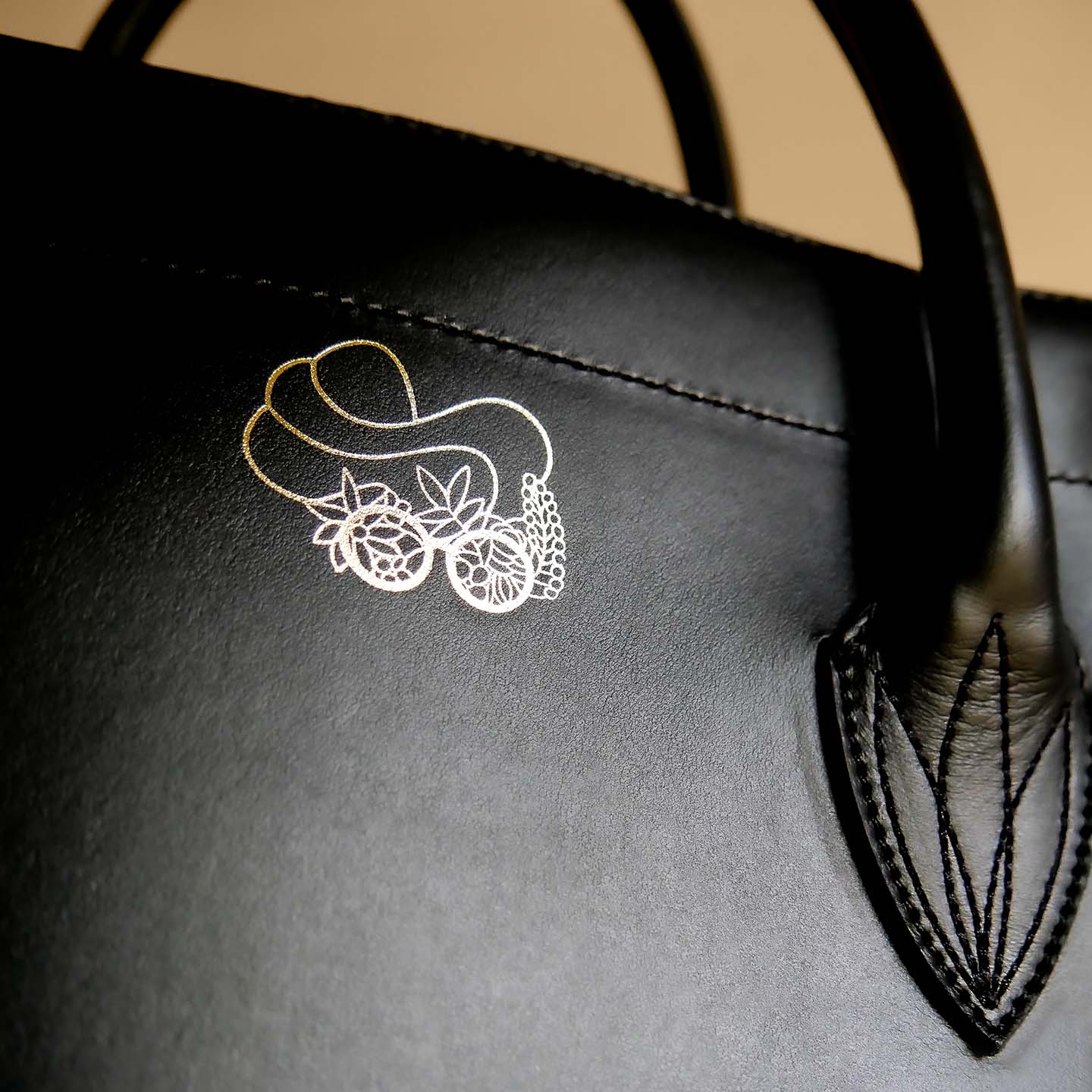 Eleganter Shopper aus Leder schwarz Detailansicht Logo gold