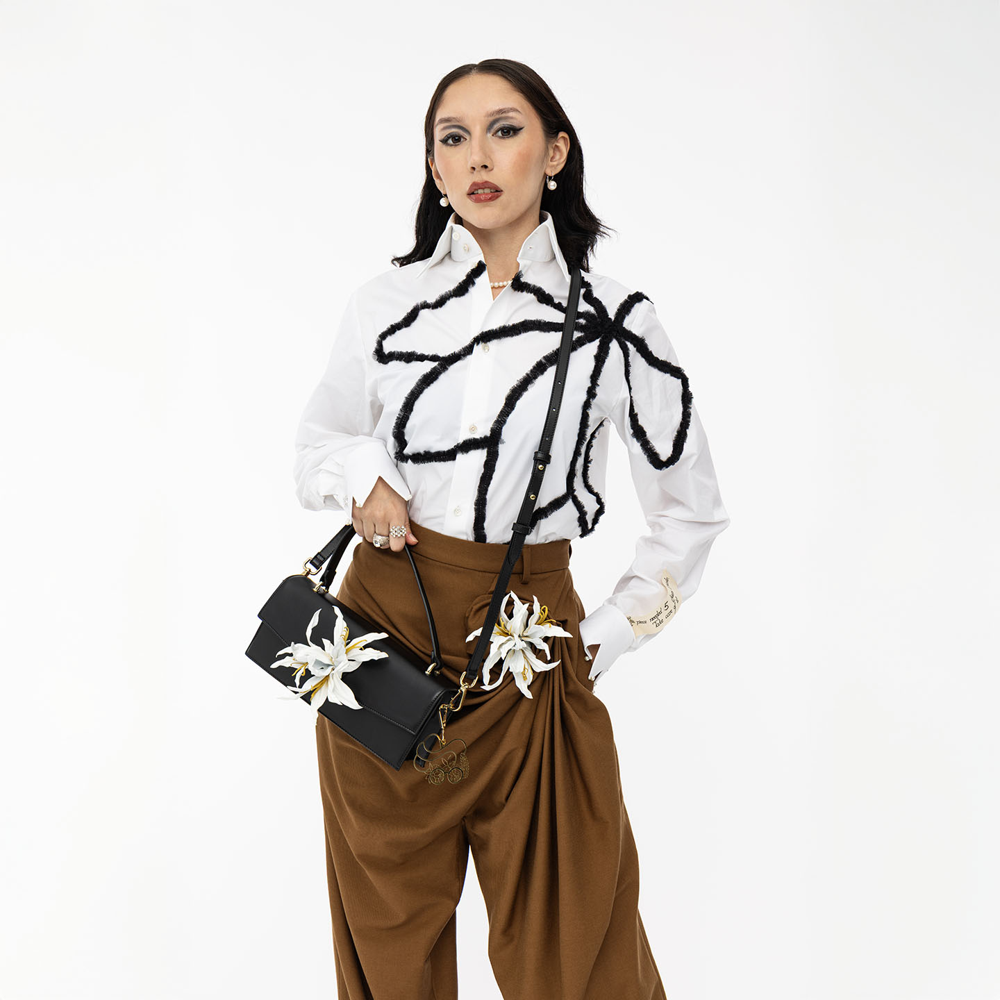 klassische Lederhandtasche schwarz mit Blume als Crossbody bag getragen