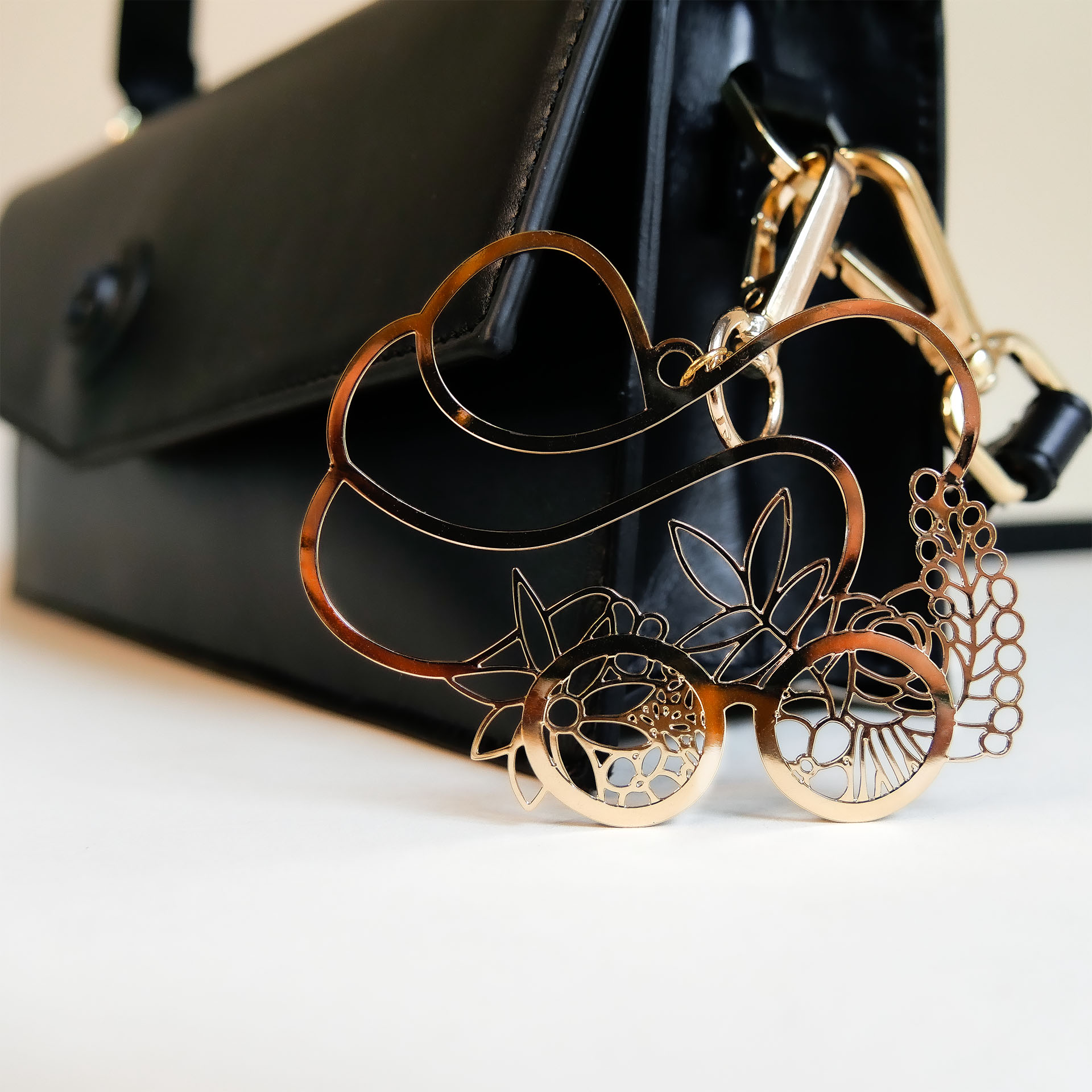 klassische Lederhandtasche schwarz. Logo Anhänger gold