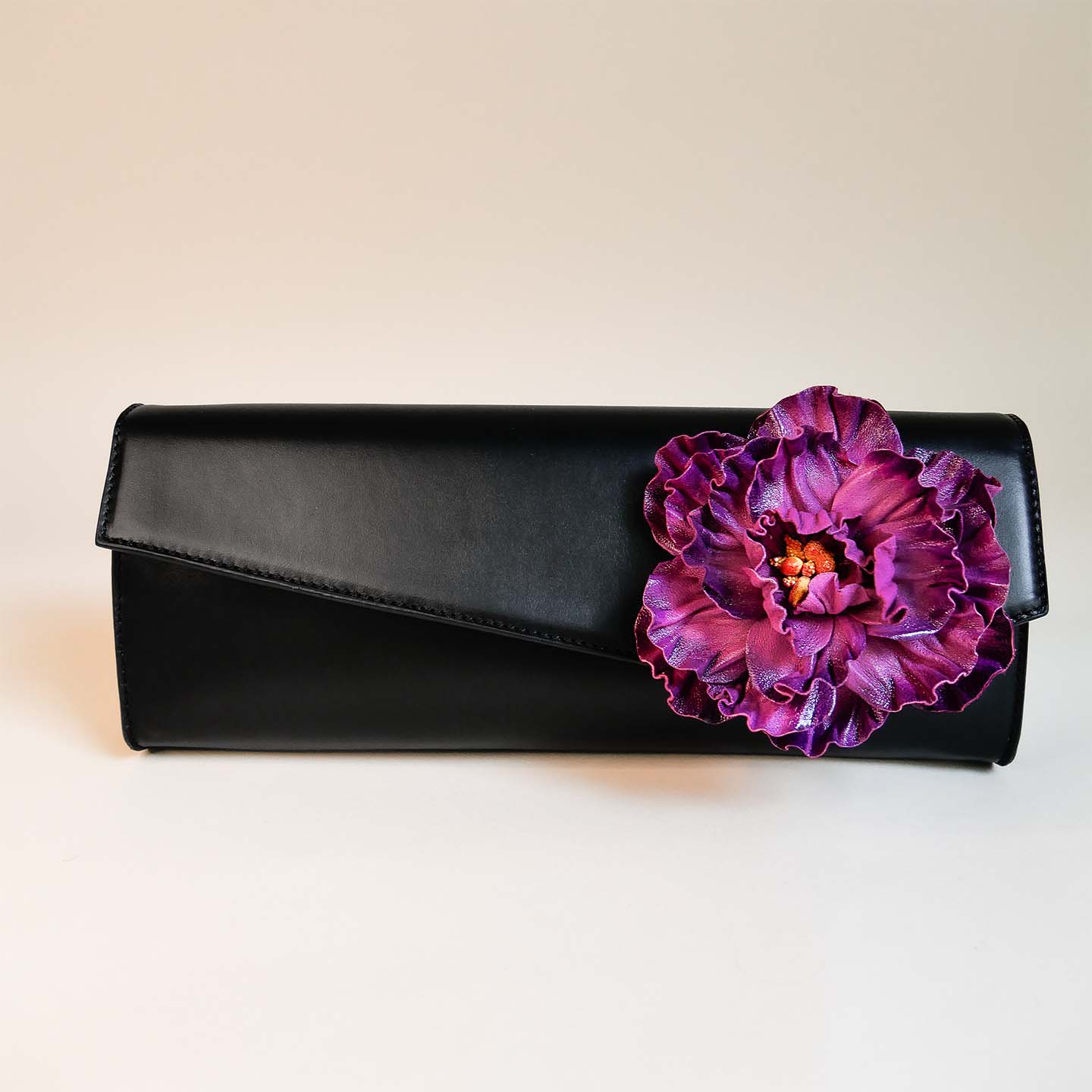 Clutch aus schwarzem Leder mit violetter Blume auf Front