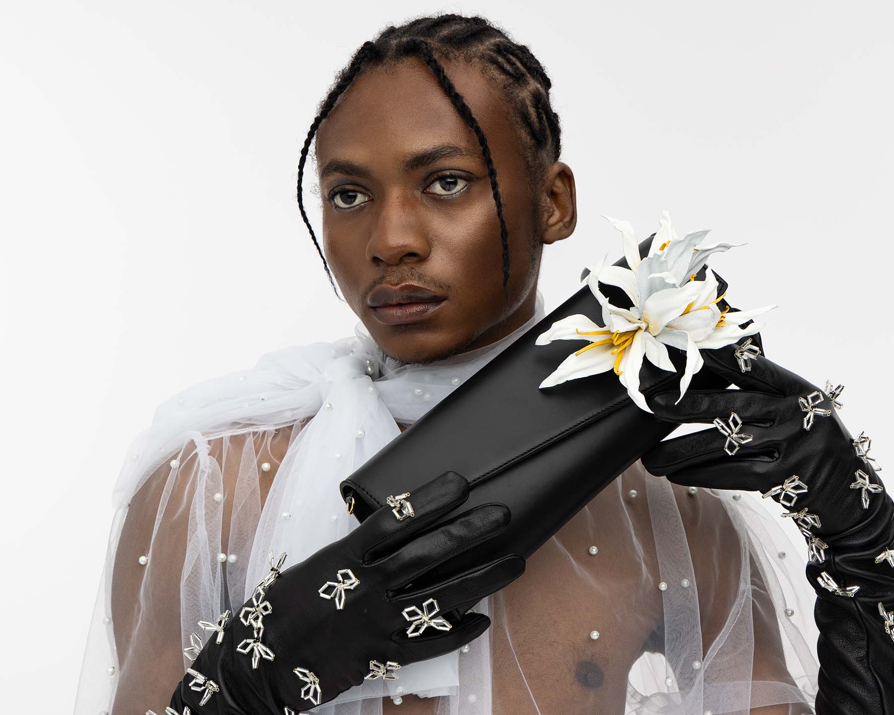 Clutch Tasche aus schwarzem Leder mit ansteckbarer weißer Lilie aus Leder, getragen von POC-Model