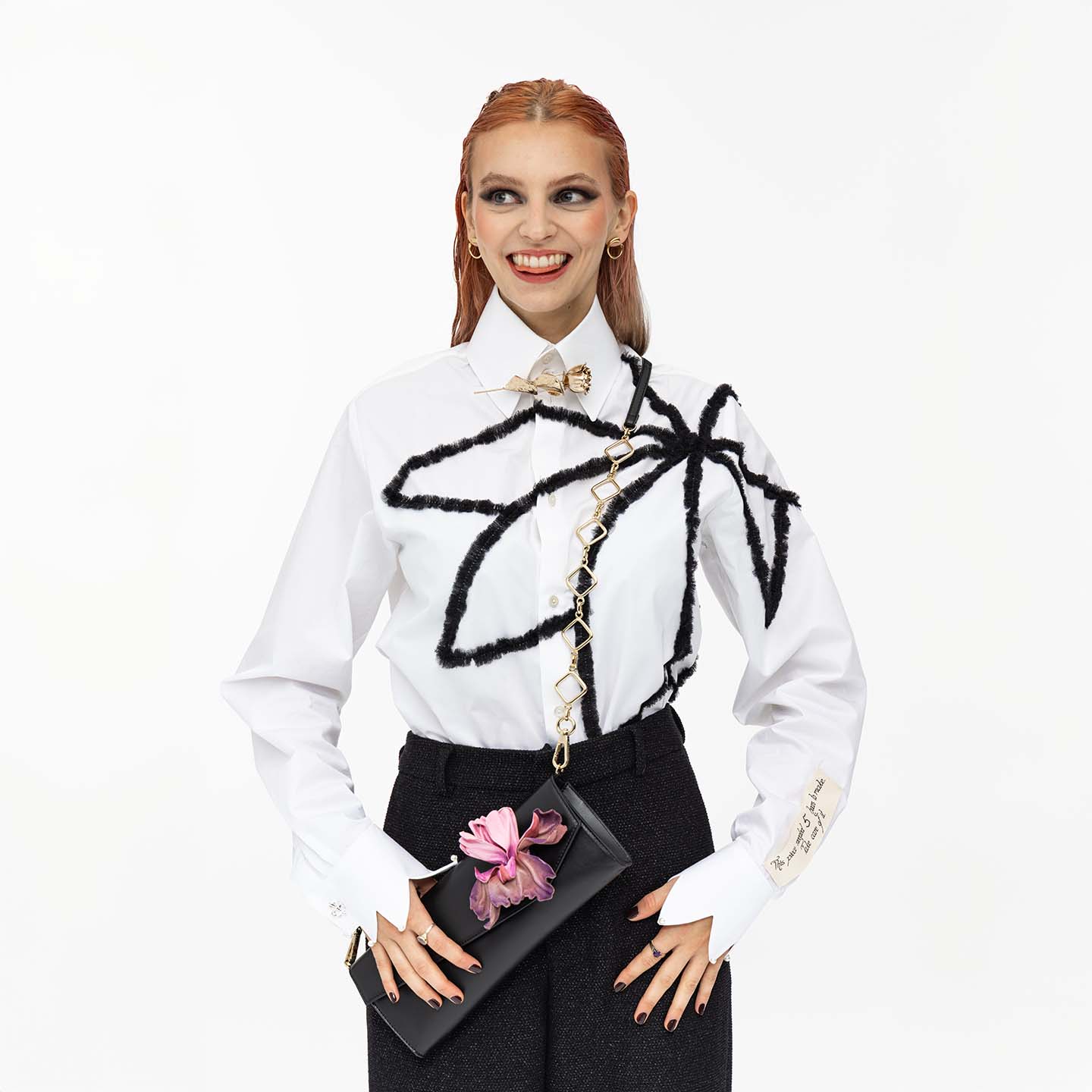 Clutch aus Leder Modell "Posy" mit Lederblume Iris in lila, getragen als Crossbody-bag von Model