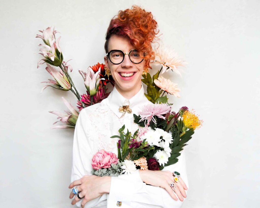 Jannik Kurz, Modedesigner für junges Modelabel "L'ANTOFOLIE" Portrait vor weißem Hintergrund mit Blumen umrandet