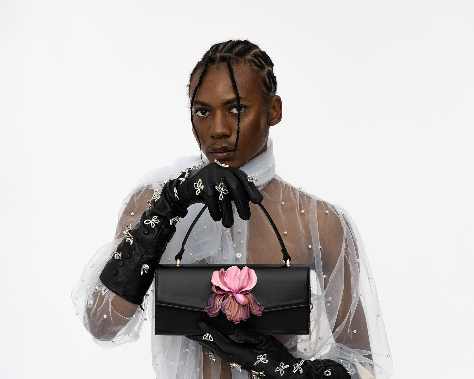 Klassische Handtasche in schwarzem Leder mit austauschbarer Irisblume aus Leder, gehalten von POC-Model