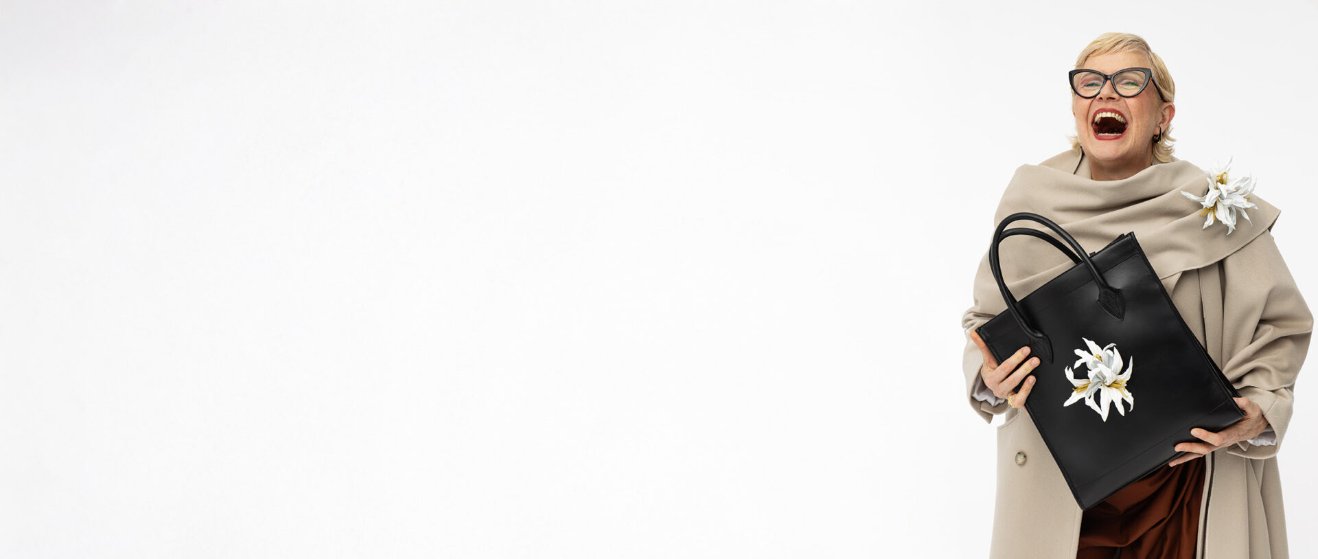 Shopper aus Leder in Schwarz mit abnehmbarer weißer Lilie, getragen von Model